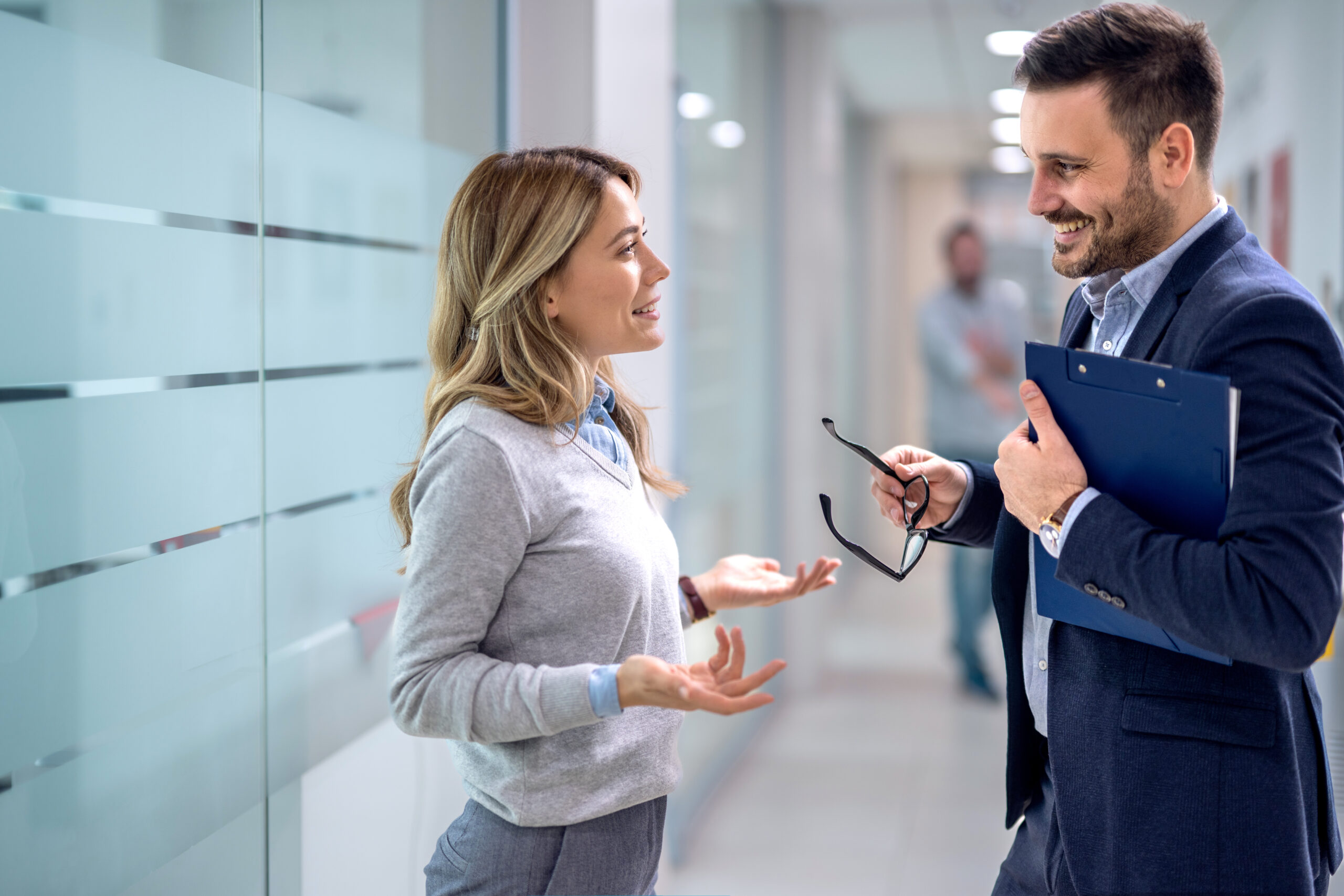 Business executive discussion with employee meeting in office lobby. Two diverse professionals discussing project strategy and corporate plan of their company.